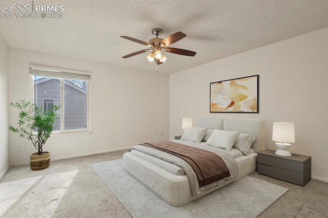 carpeted bedroom featuring ceiling fan and a textured ceiling