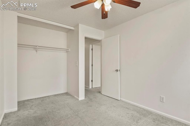 unfurnished bedroom featuring ceiling fan, light colored carpet, and a textured ceiling