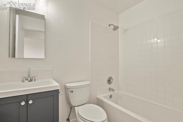 full bathroom featuring vanity, tiled shower / bath combo, and toilet