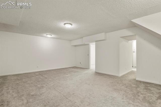 basement with light colored carpet and a textured ceiling