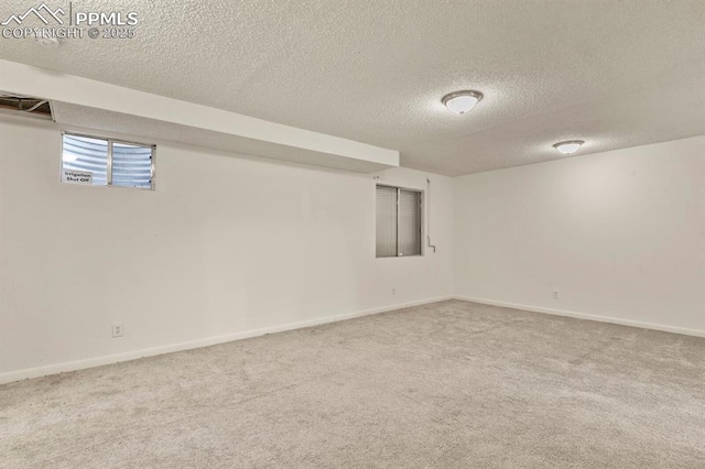 basement featuring light colored carpet and a textured ceiling