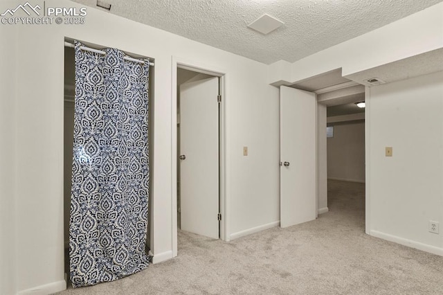 interior space with light carpet and a textured ceiling