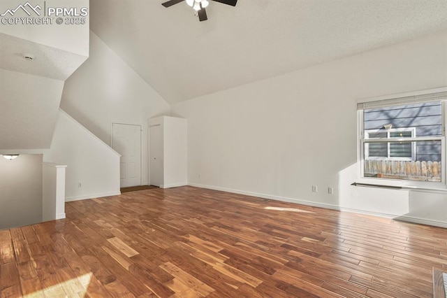 unfurnished living room featuring hardwood / wood-style flooring, ceiling fan, and a high ceiling