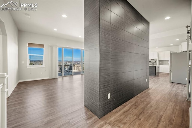 hall featuring recessed lighting, baseboards, and wood finished floors