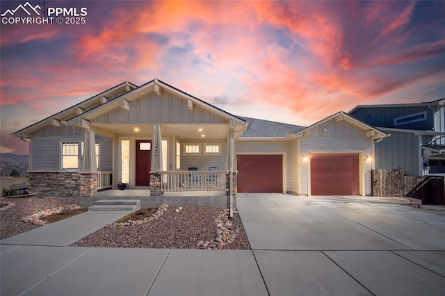 view of front of home with a porch, a garage, driveway, and board and batten siding