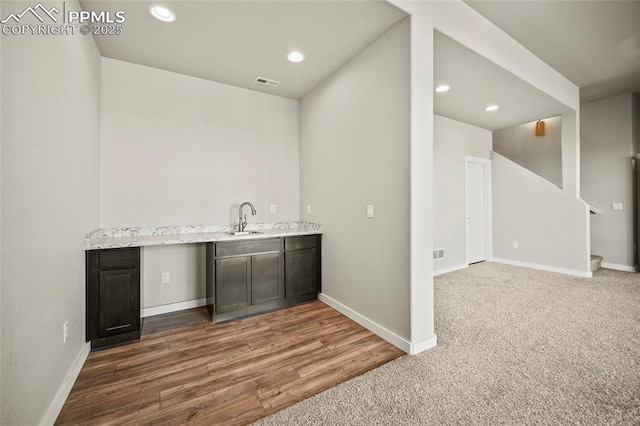 bar featuring baseboards, visible vents, a sink, and recessed lighting