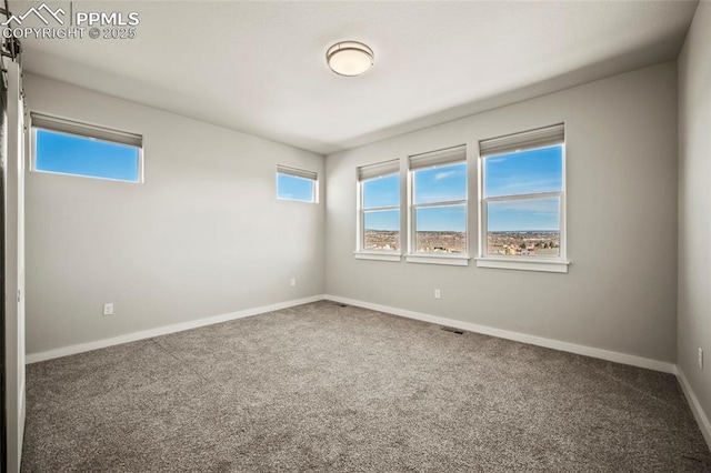 carpeted empty room with visible vents and baseboards