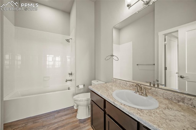 bathroom featuring shower / bathtub combination, vanity, toilet, and wood finished floors