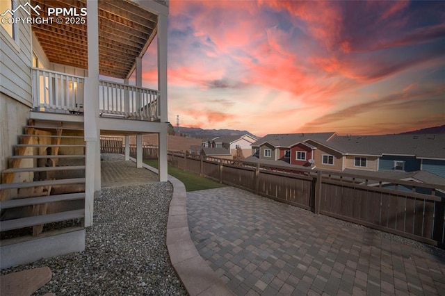 view of patio with stairway, fence, and a residential view