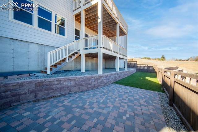 view of home's exterior featuring a patio area, a fenced backyard, stairway, and a yard