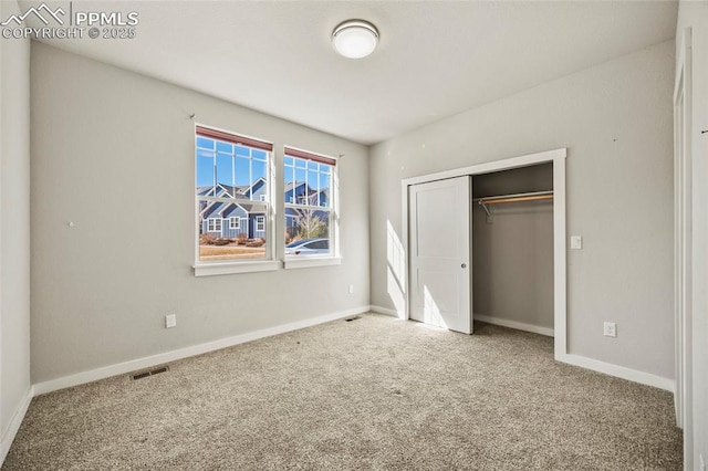 unfurnished bedroom with a closet, carpet flooring, visible vents, and baseboards