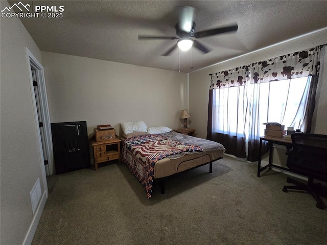 carpeted bedroom with ceiling fan and a textured ceiling