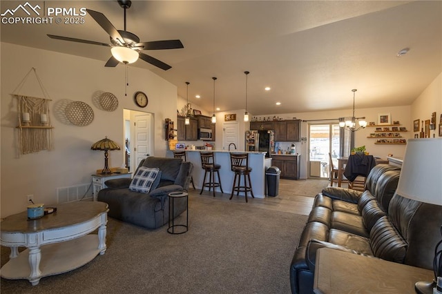 living room featuring vaulted ceiling and ceiling fan with notable chandelier