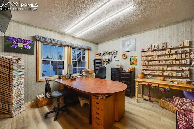 home office featuring a textured ceiling and light hardwood / wood-style floors