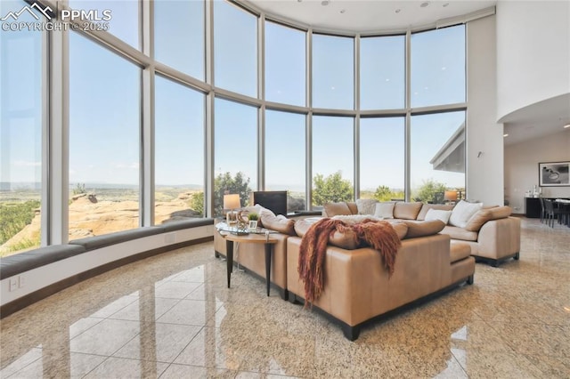 living room featuring floor to ceiling windows and a towering ceiling