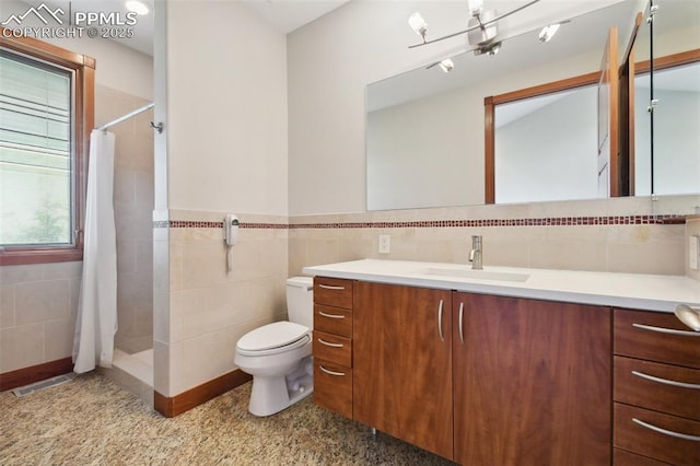 bathroom with curtained shower, toilet, tile walls, and vanity