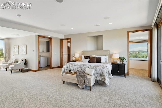 bedroom with multiple windows, washer / dryer, and light colored carpet