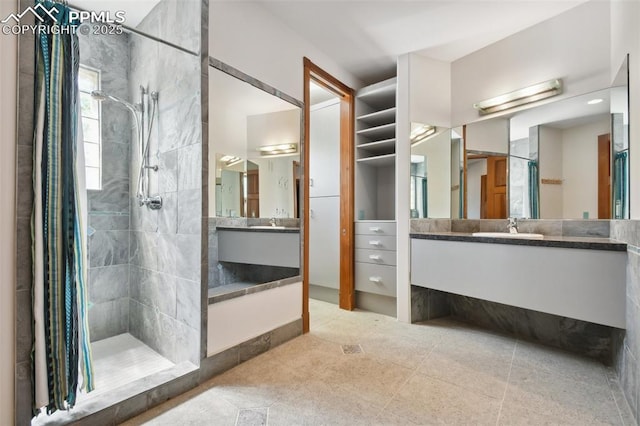 bathroom with tile patterned floors, tiled shower, and vanity