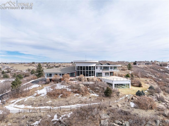 rear view of house with a rural view and a sunroom