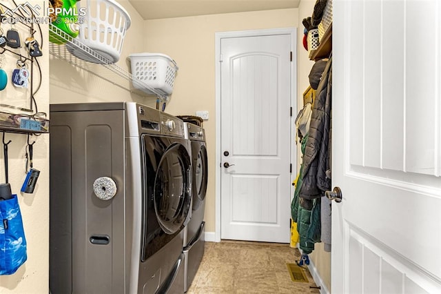 clothes washing area with laundry area, separate washer and dryer, and visible vents