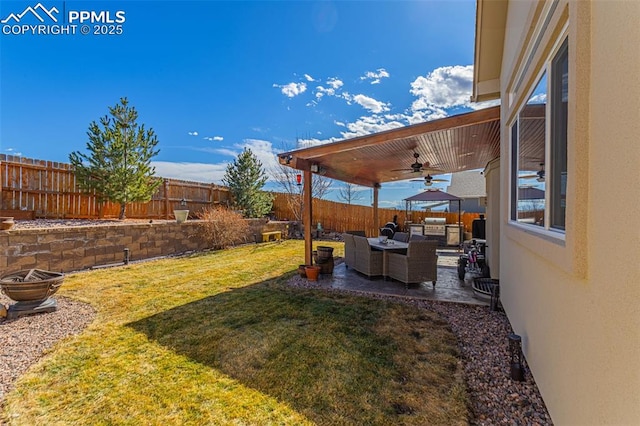 view of yard featuring a fenced backyard, ceiling fan, outdoor lounge area, and a patio