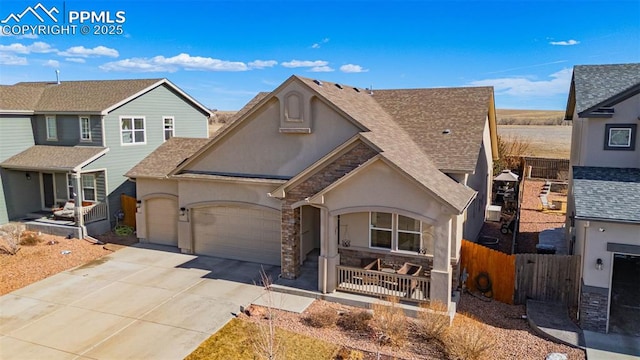 traditional home featuring roof with shingles, stucco siding, a porch, concrete driveway, and a garage