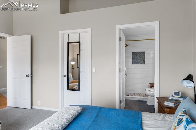 bedroom featuring ensuite bathroom and dark carpet