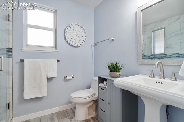 bathroom featuring a shower with door, wood-type flooring, sink, and toilet