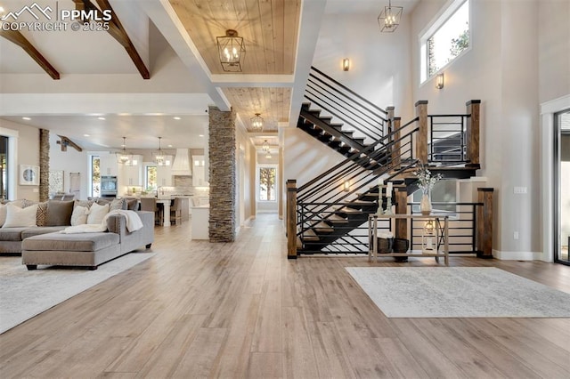 foyer with an inviting chandelier, hardwood / wood-style flooring, and beam ceiling