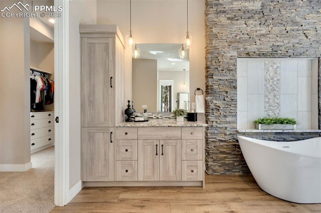 bathroom featuring vanity, a bathtub, and hardwood / wood-style flooring