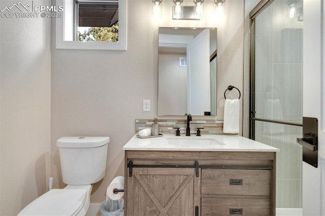 bathroom featuring tasteful backsplash, vanity, toilet, and an enclosed shower