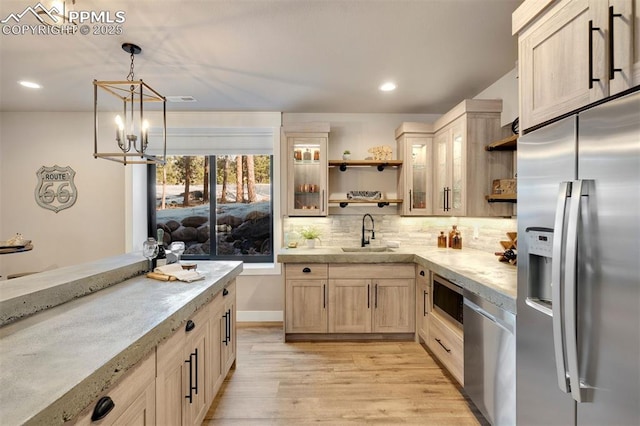 kitchen featuring light brown cabinetry, sink, decorative backsplash, hanging light fixtures, and stainless steel appliances