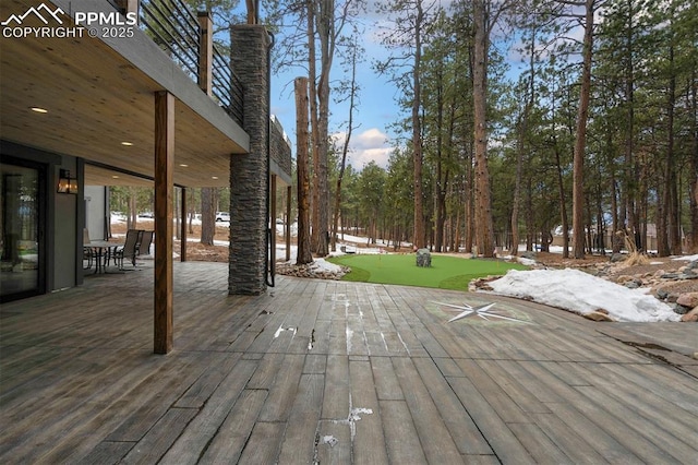 snow covered deck with a lawn