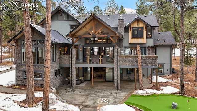 snow covered property featuring a patio, a balcony, and a deck