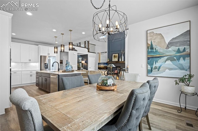 dining area featuring sink, hardwood / wood-style floors, and a notable chandelier