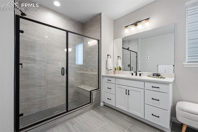 bathroom with vanity and a shower with door