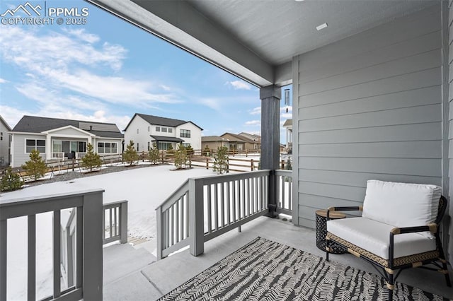 snow covered back of property with a porch