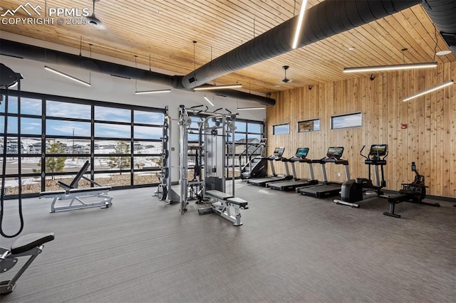 gym with wood ceiling, wooden walls, and a high ceiling