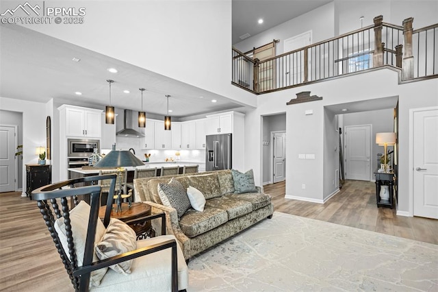 living room featuring a high ceiling and light hardwood / wood-style flooring