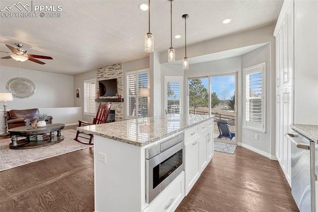 kitchen featuring appliances with stainless steel finishes, a kitchen island, hanging light fixtures, and white cabinets