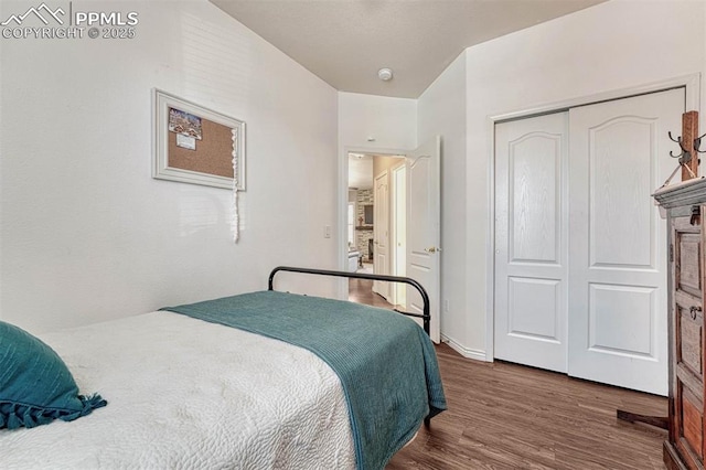 bedroom with dark hardwood / wood-style floors and a closet