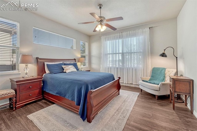 bedroom with wood-type flooring, a textured ceiling, and ceiling fan