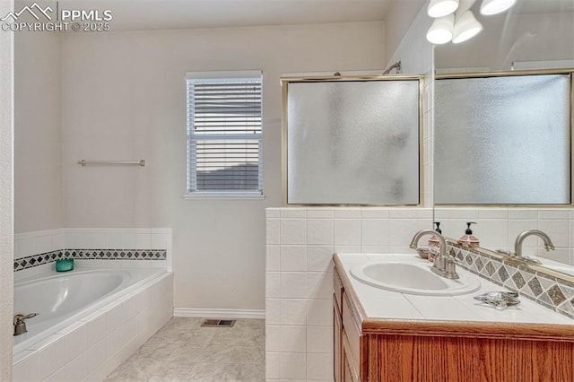 bathroom with independent shower and bath, vanity, and backsplash