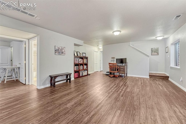 interior space with wood-type flooring and a textured ceiling