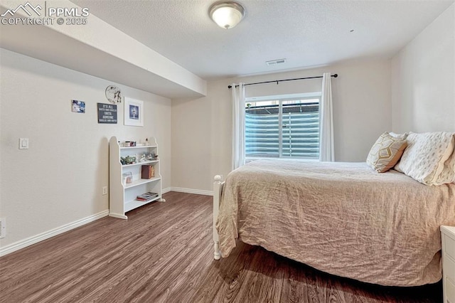 bedroom with hardwood / wood-style floors and a textured ceiling