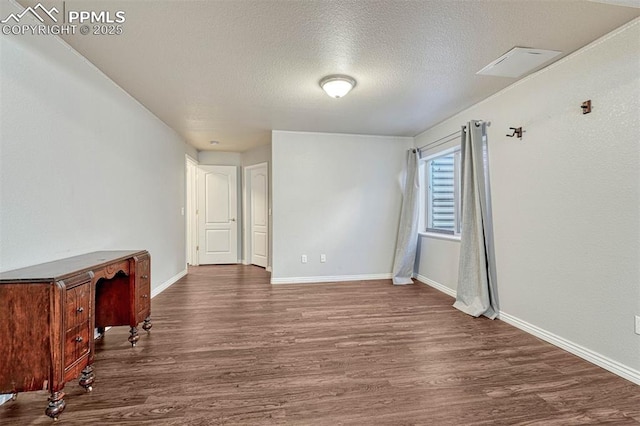 empty room with a textured ceiling and dark hardwood / wood-style flooring