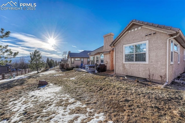 view of side of home featuring a mountain view and a patio area