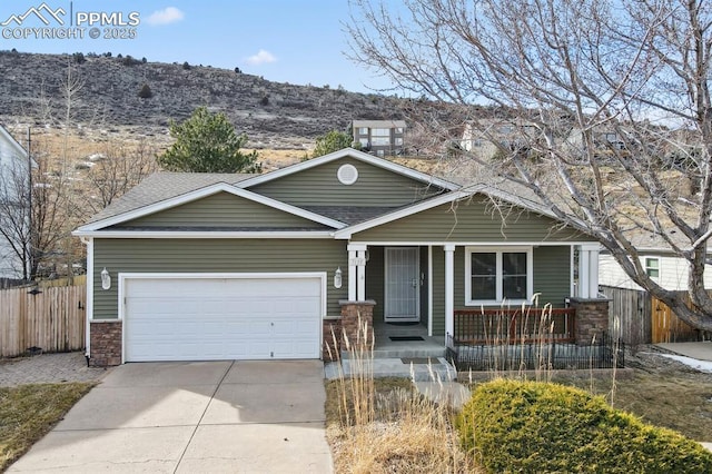 craftsman-style home with a garage, a mountain view, and covered porch