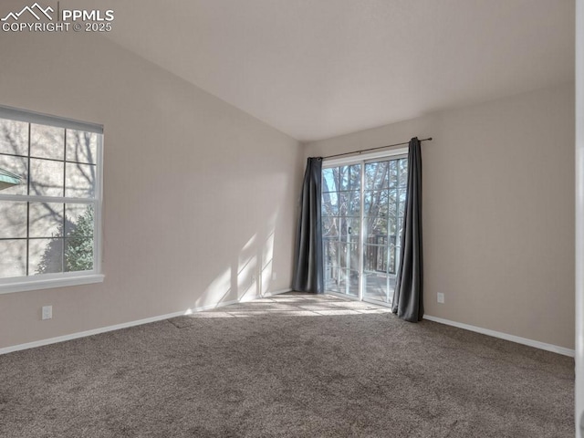 carpeted spare room with vaulted ceiling