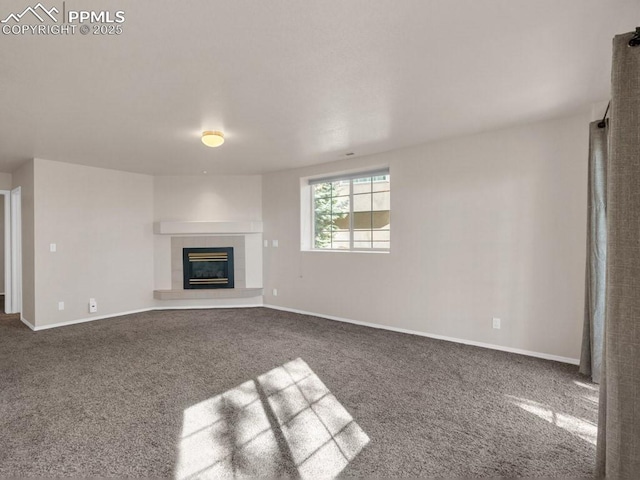 unfurnished living room featuring carpet flooring and a tile fireplace